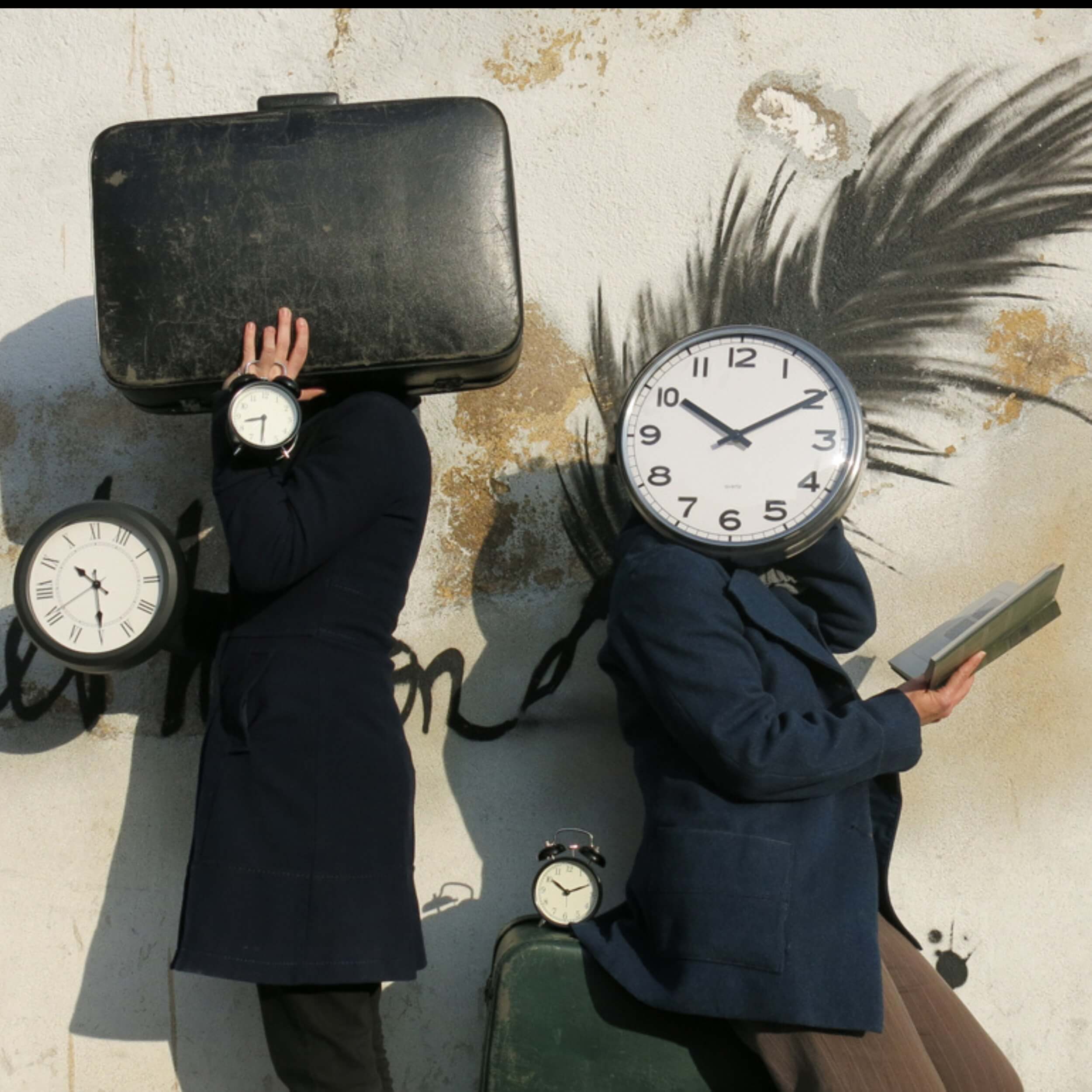 Deux humains, 4 horloges, 1 valise, 1 livre